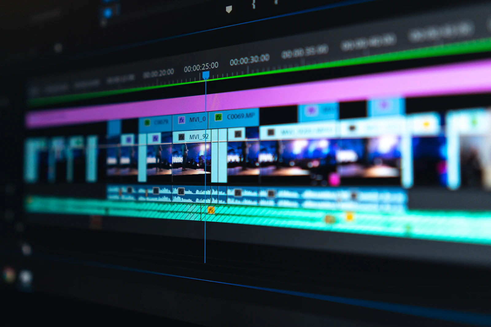 Close-up of a video editing timeline with colour-coded clips on a monitor