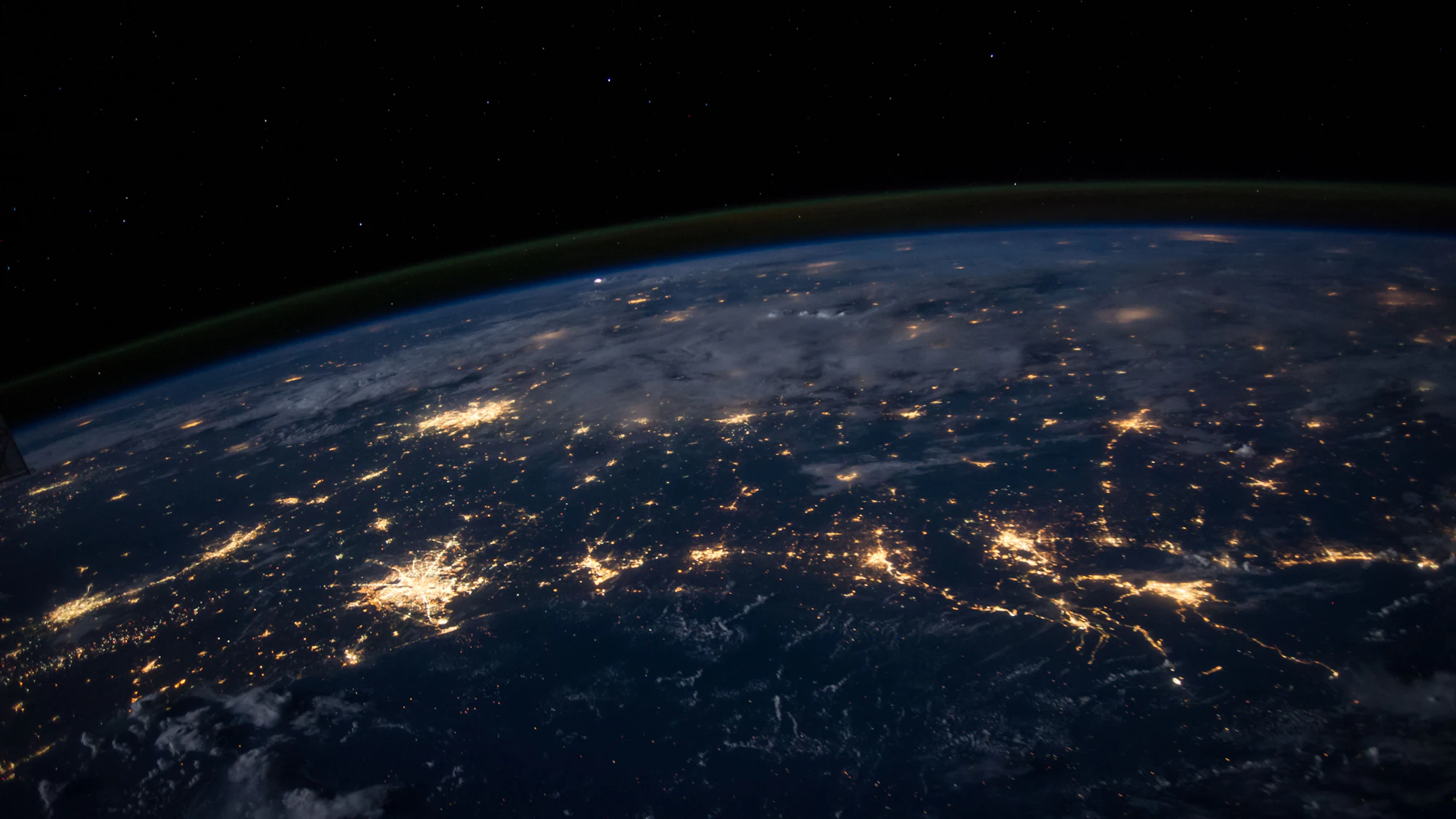 The Earth at night seen from space, with city lights glowing across continents