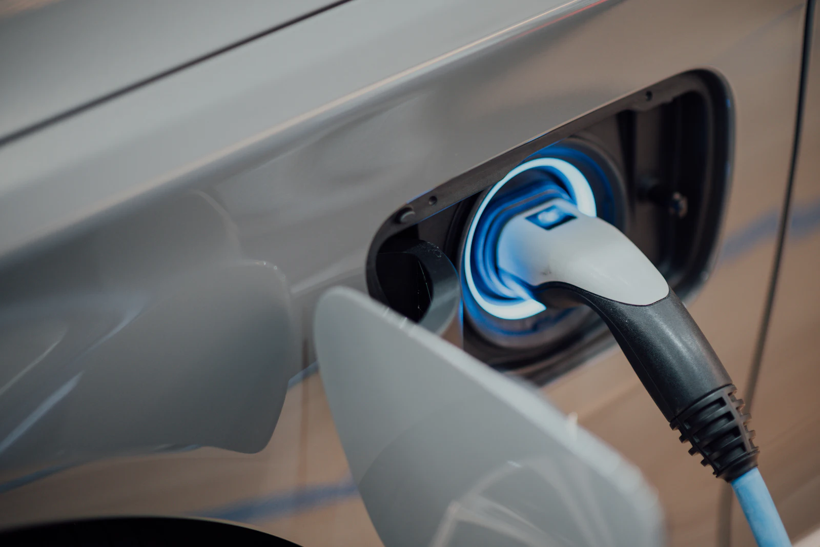 An electric vehicle charging connector plugged into a car's charging port