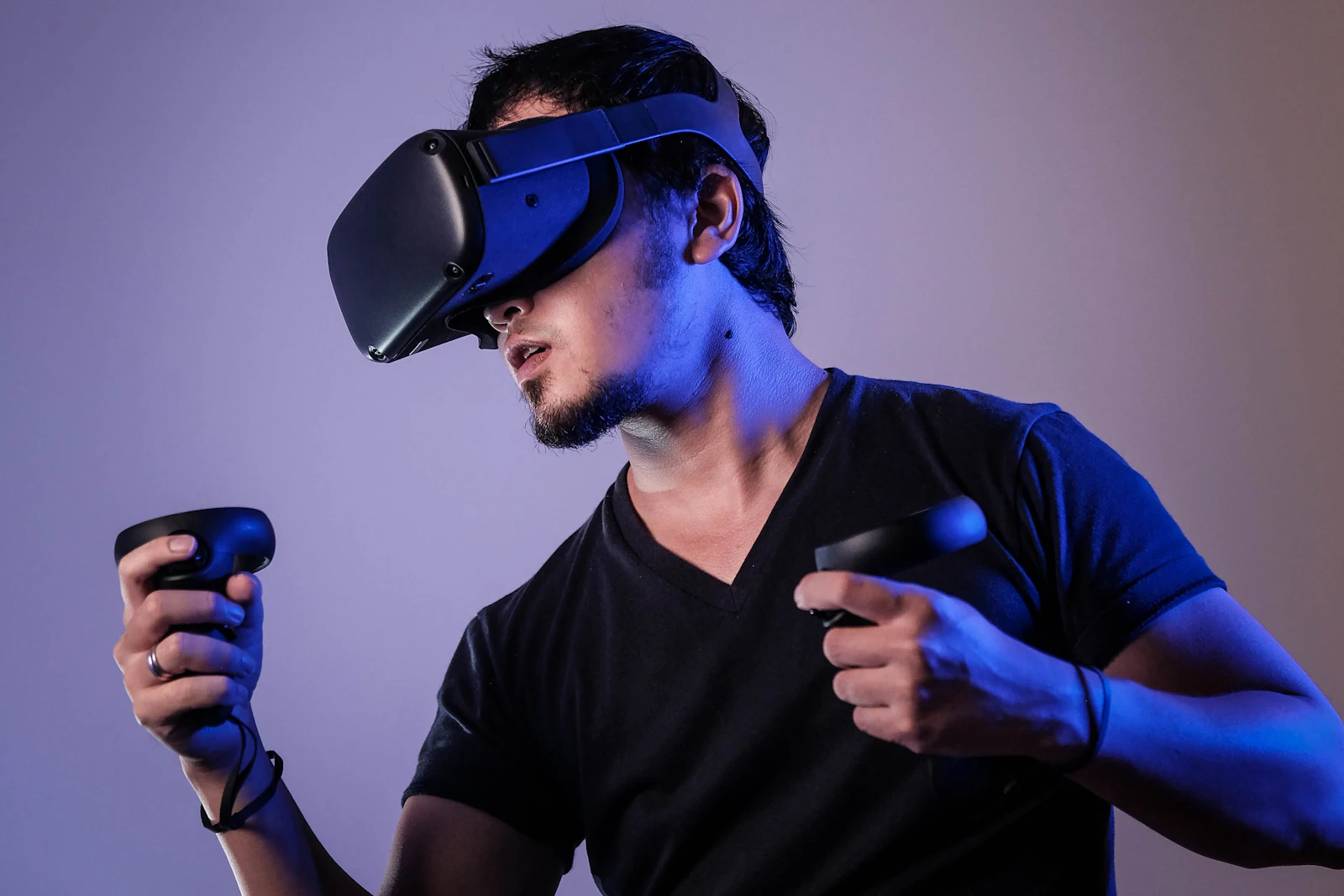 A gamer immersed in play wearing a virtual reality headset and motion controllers