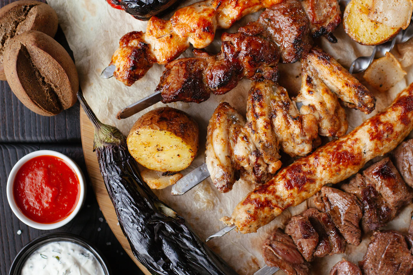 Grilled skewers of meat and vegetables served on a wooden board